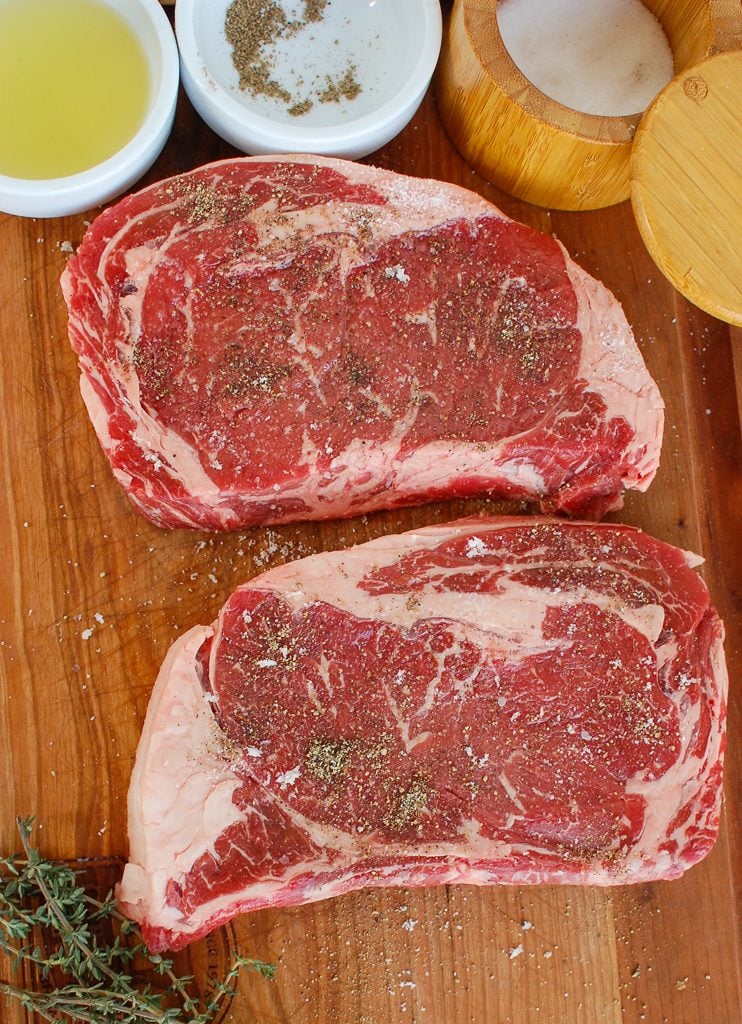 Pan-Seared Ribeye with Goat Cheese and Sun-dried Tomatoes on cutting board