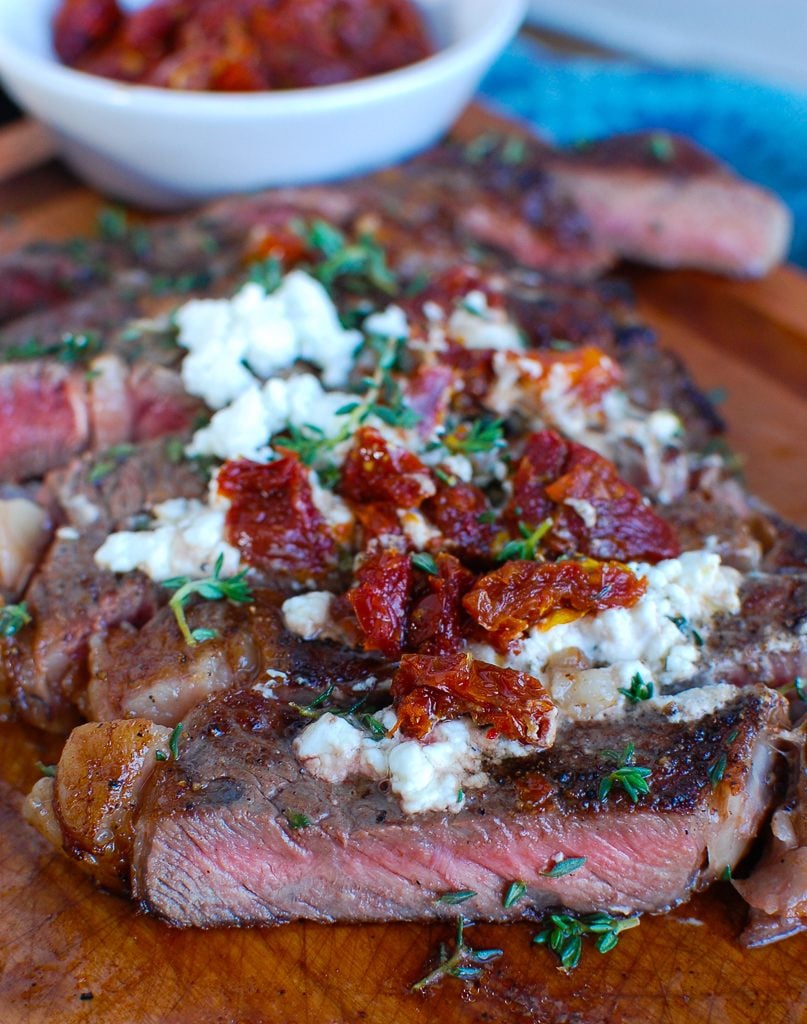 Pan-Seared Ribeye with Goat Cheese and Sun-dried Tomatoes Cut on Board 