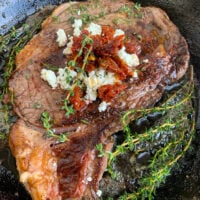 Pan-Seared Ribeye with Goat Cheese and Sun-dried Tomatoes in Skillet