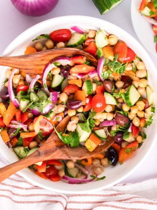 Mediterranean Chickpea Salad with two wooden spoons