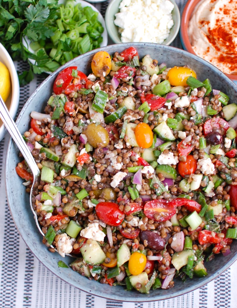 Mediterranean Lentil Salad in a blue bowl with silver spoon