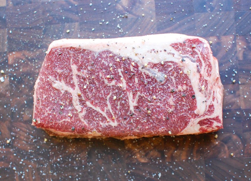 Lemon Garlic Butter Grilled Ribeye on cutting board with salt