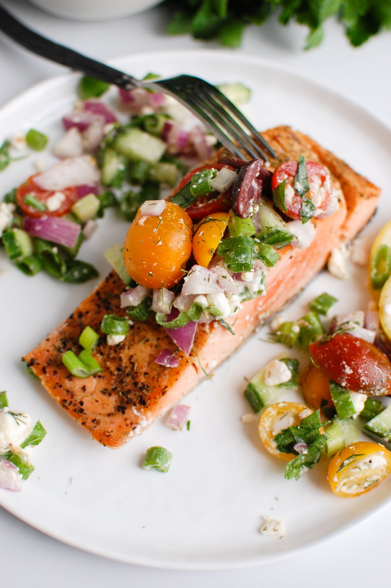 a fork cutting into a filet of salmon.