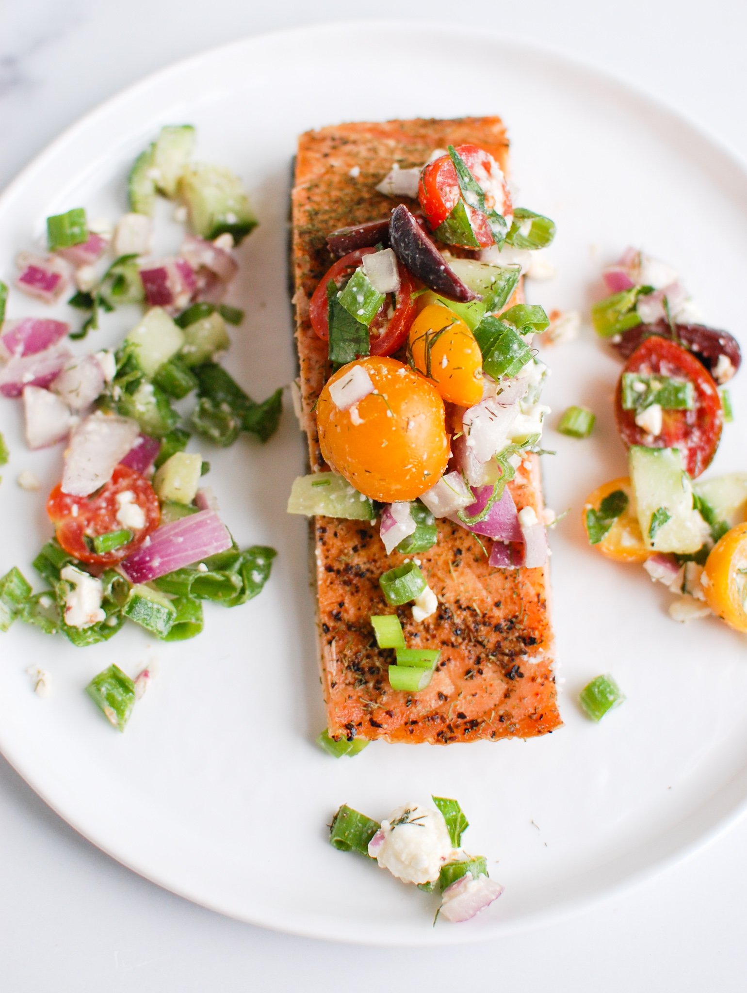 a salmon filet topped with fresh tomatoes and herbs. 