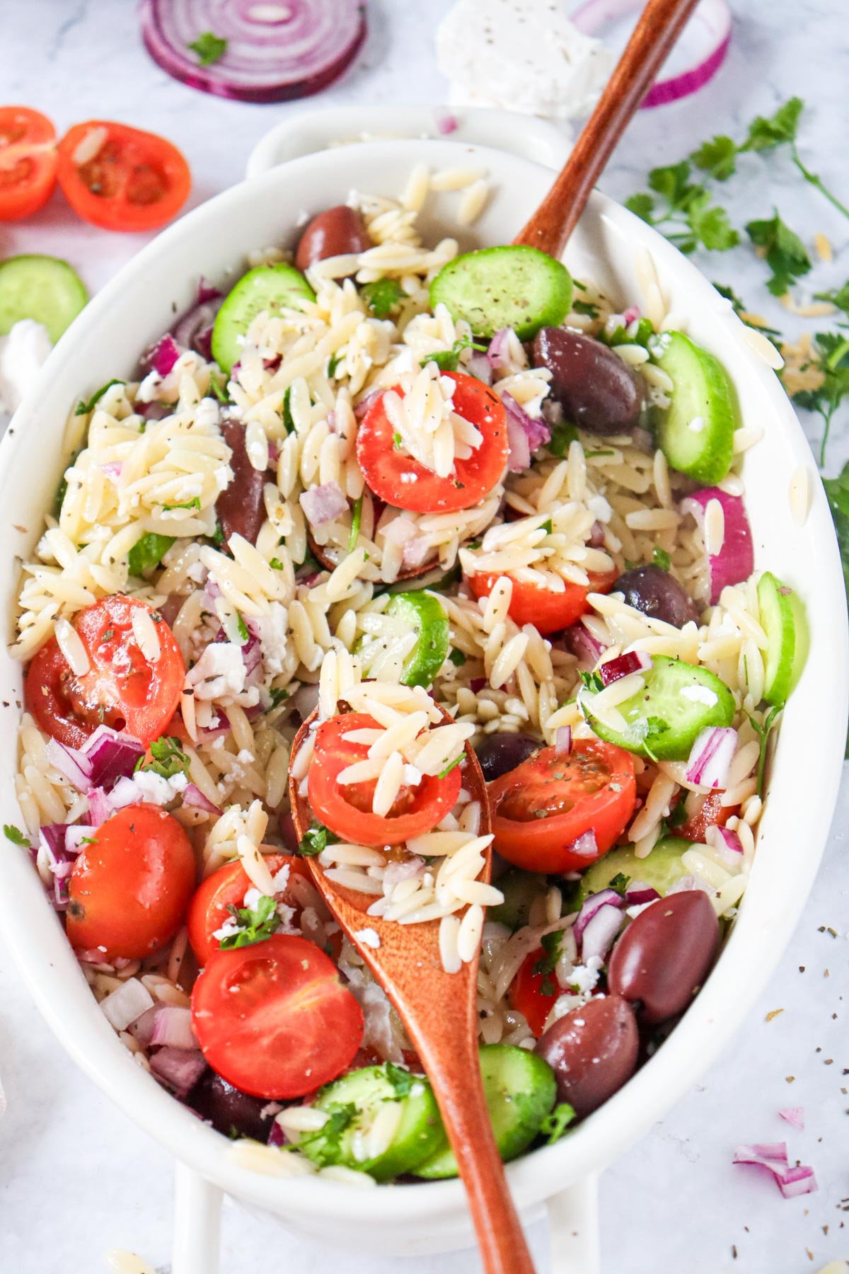 Greek Orzo Pasta Salad with wooden spoon 