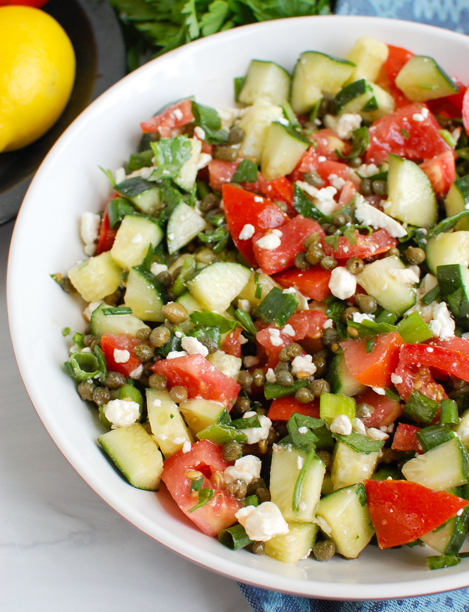 Tomato and Cucumber Salad with Capers in white bowl
