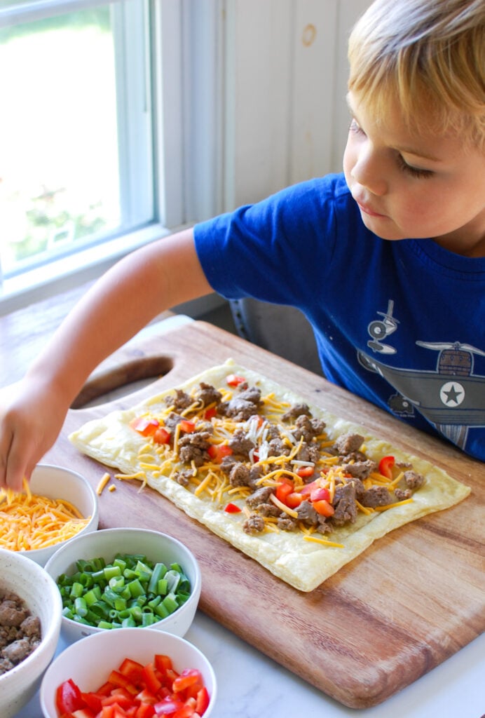 Turkey Sausage and Egg Puff Pastry Pizza with kid helping 