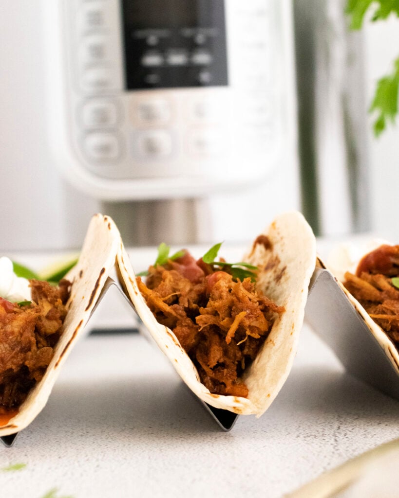 Instant Pot Carnitas Recipe tacos in a taco holder 