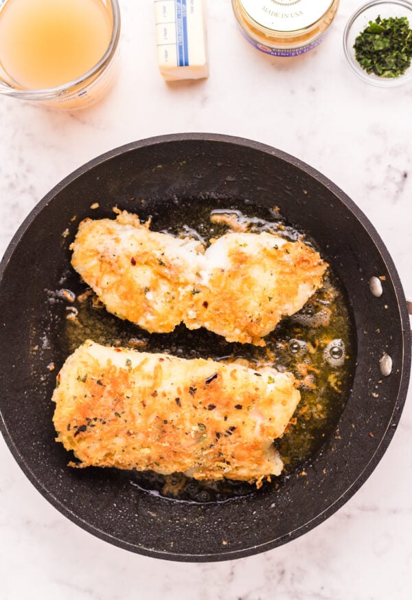 Pan Fried Garlic Butter Cod browned in skillet 