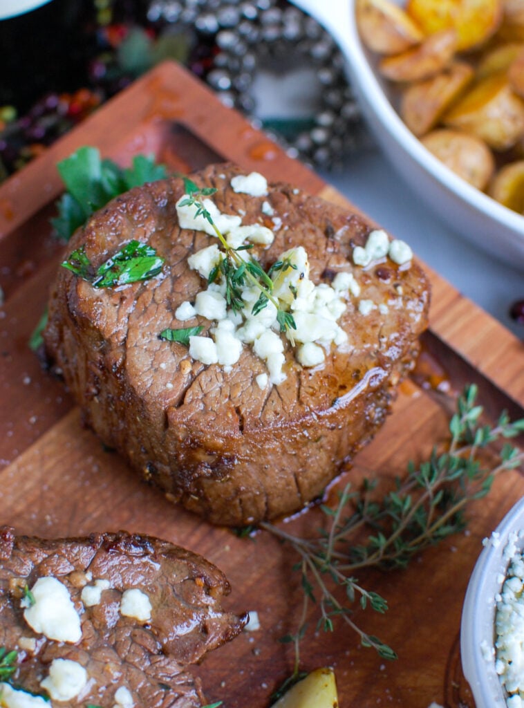 Beef Tenderloin Steaks with Creamy Blue Cheese Sauce on cutting board