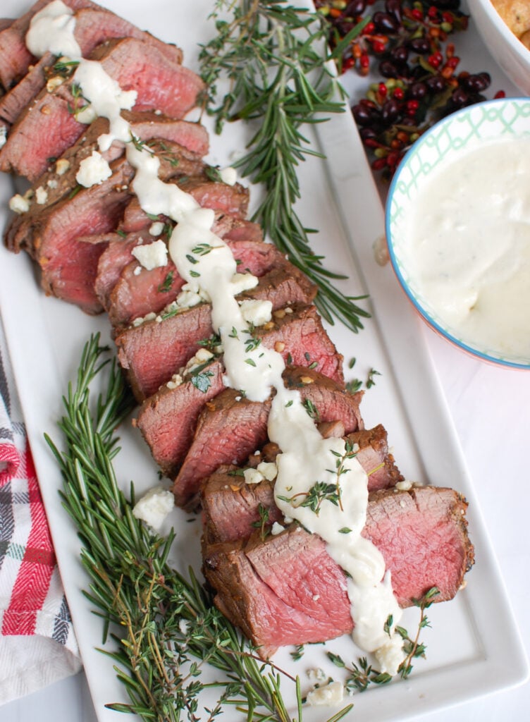 Beef Tenderloin Steaks with Creamy Blue Cheese Sauce on white platter