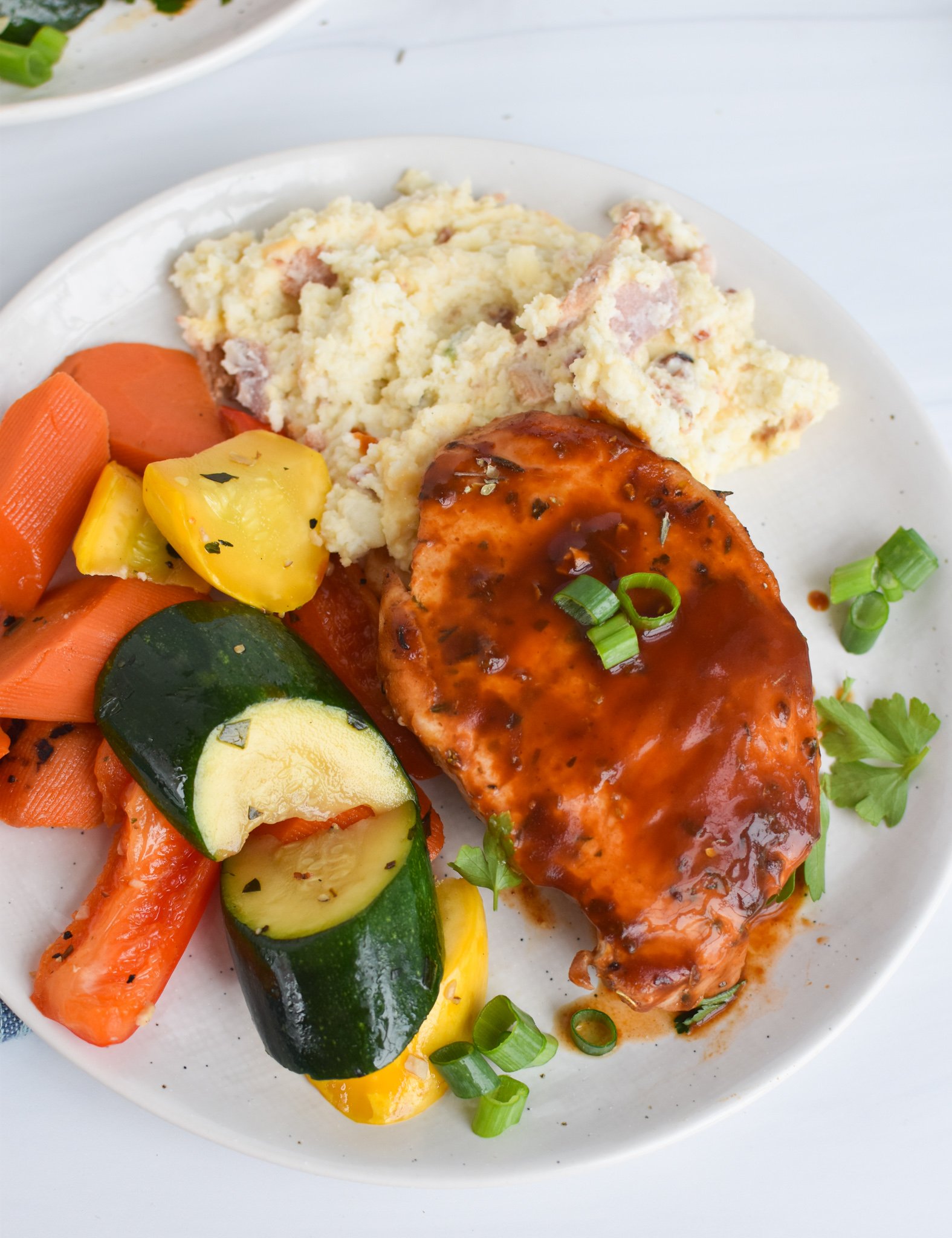 BBQ Baked Pork Chops with vegetables and mashed potatoes.