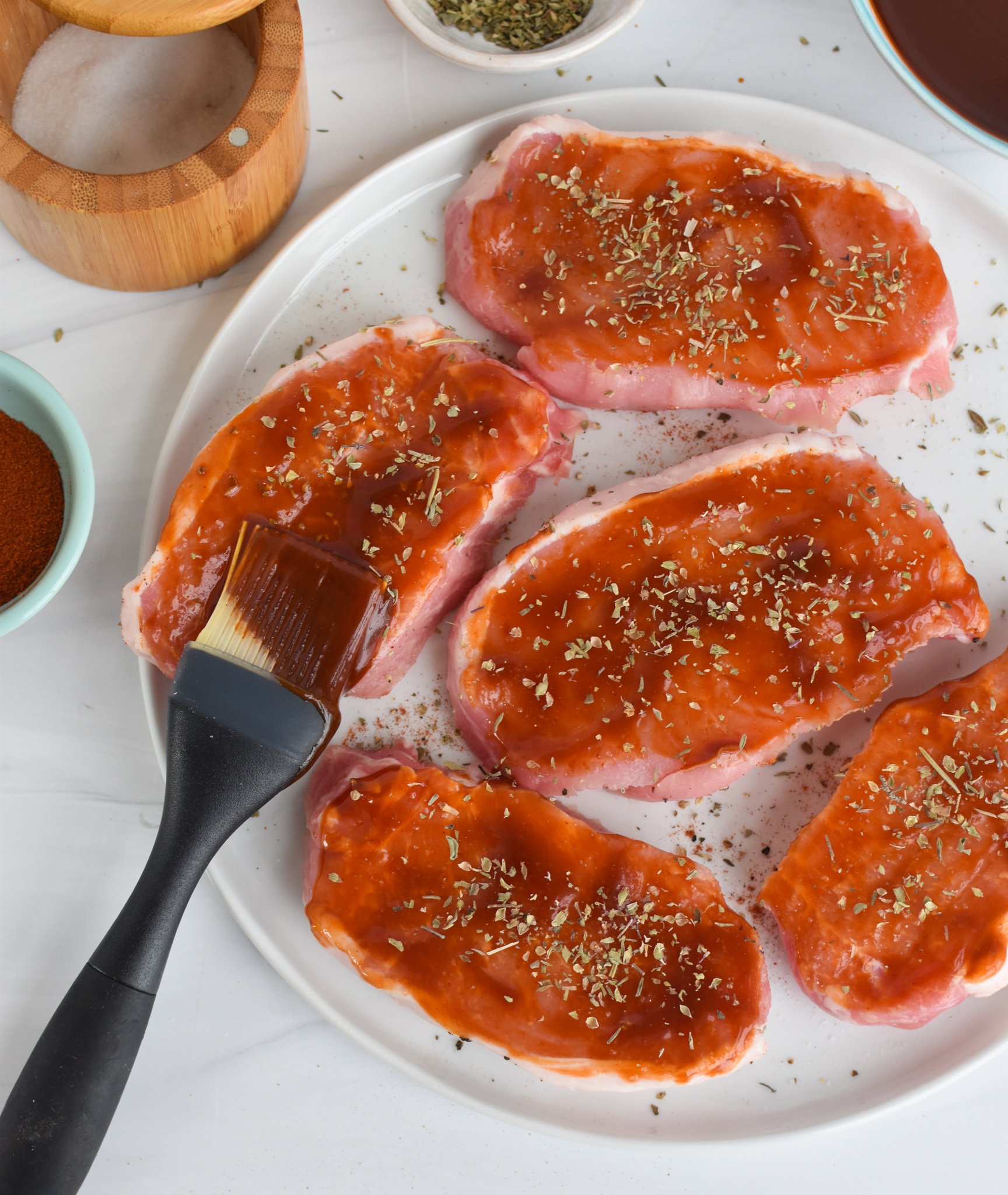 BBQ Baked Pork Chops with a brush and BBQ sauce.