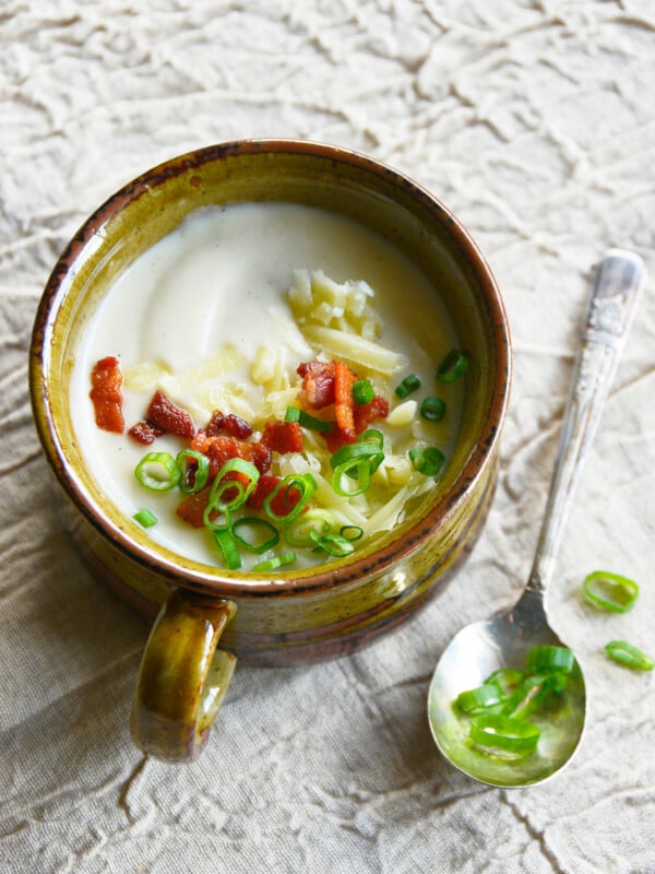Instant Pot Cauliflower Soup with spoon and green onions on top.