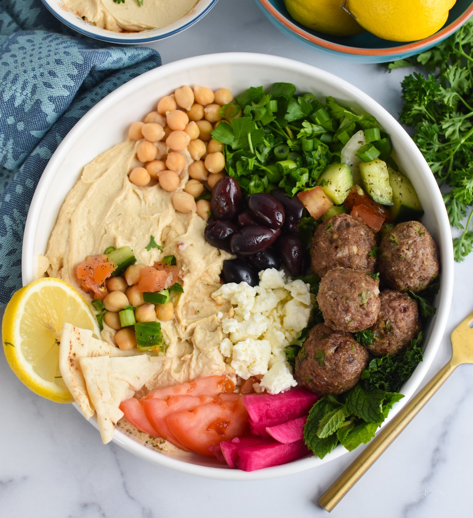 Lamb Kofta with hummus, feta cheese, tomatoes, cucumbers and green onions. 