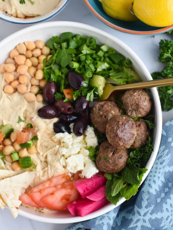 Lamb Kofta in hummus bowl with fork.