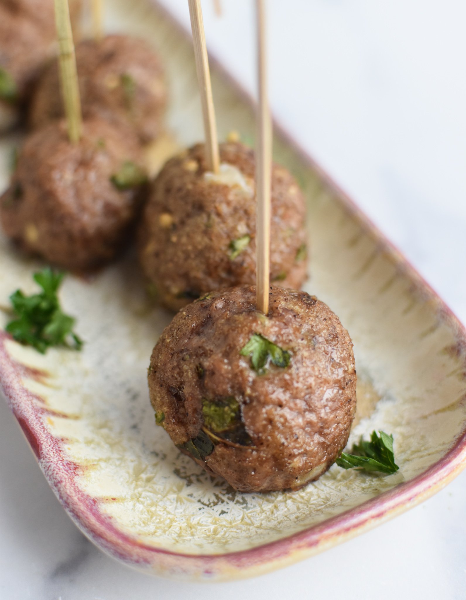 Lamb Kofta with toothpicks on an appetizer platter. 