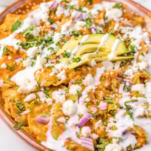 Chilaquiles Rojos Recipe on a platter with avocado on top.