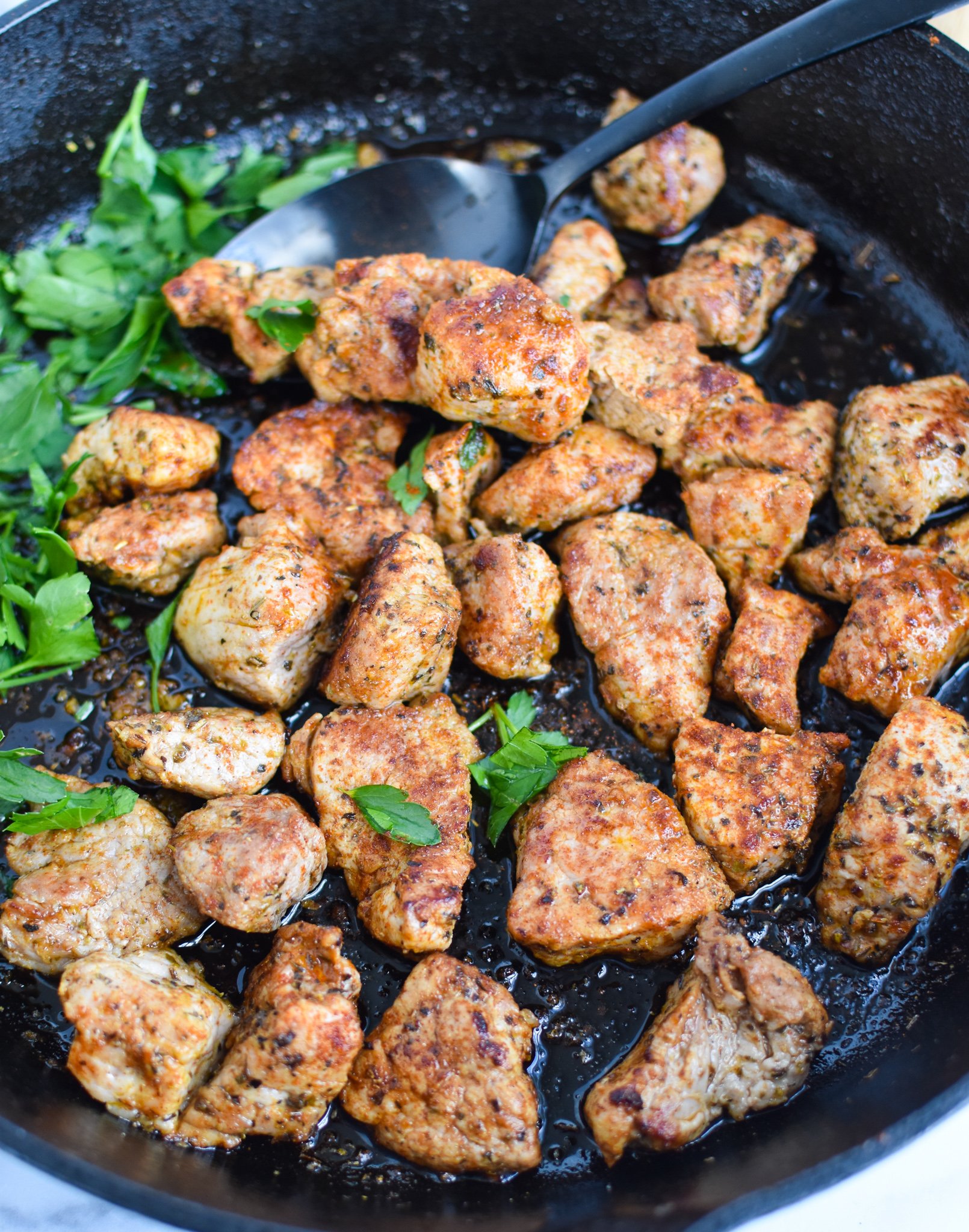 Cast Iron Pork Tenderloin with spoon.