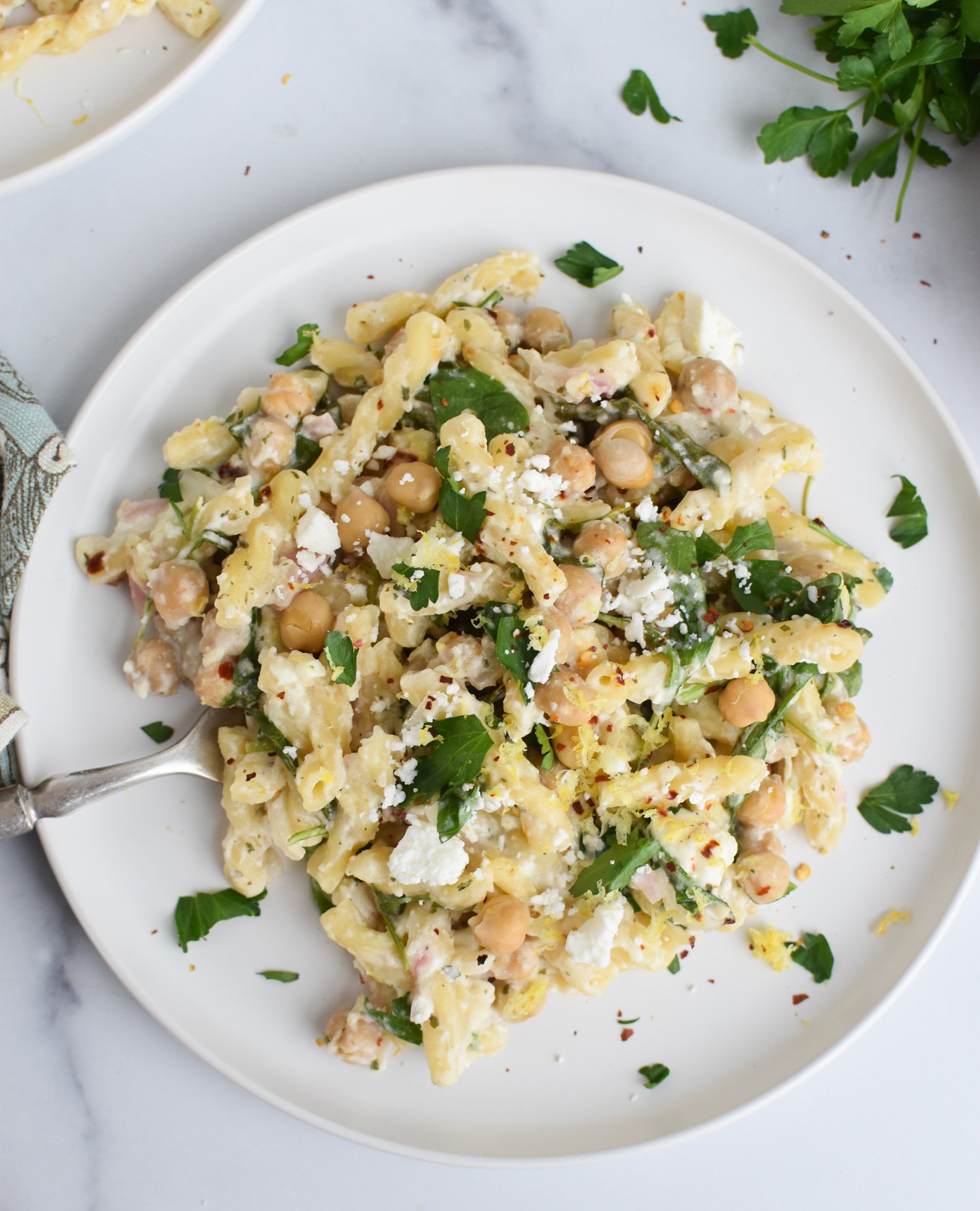 Chickpea Pasta Recipe with Feta on white plate with parsley. 