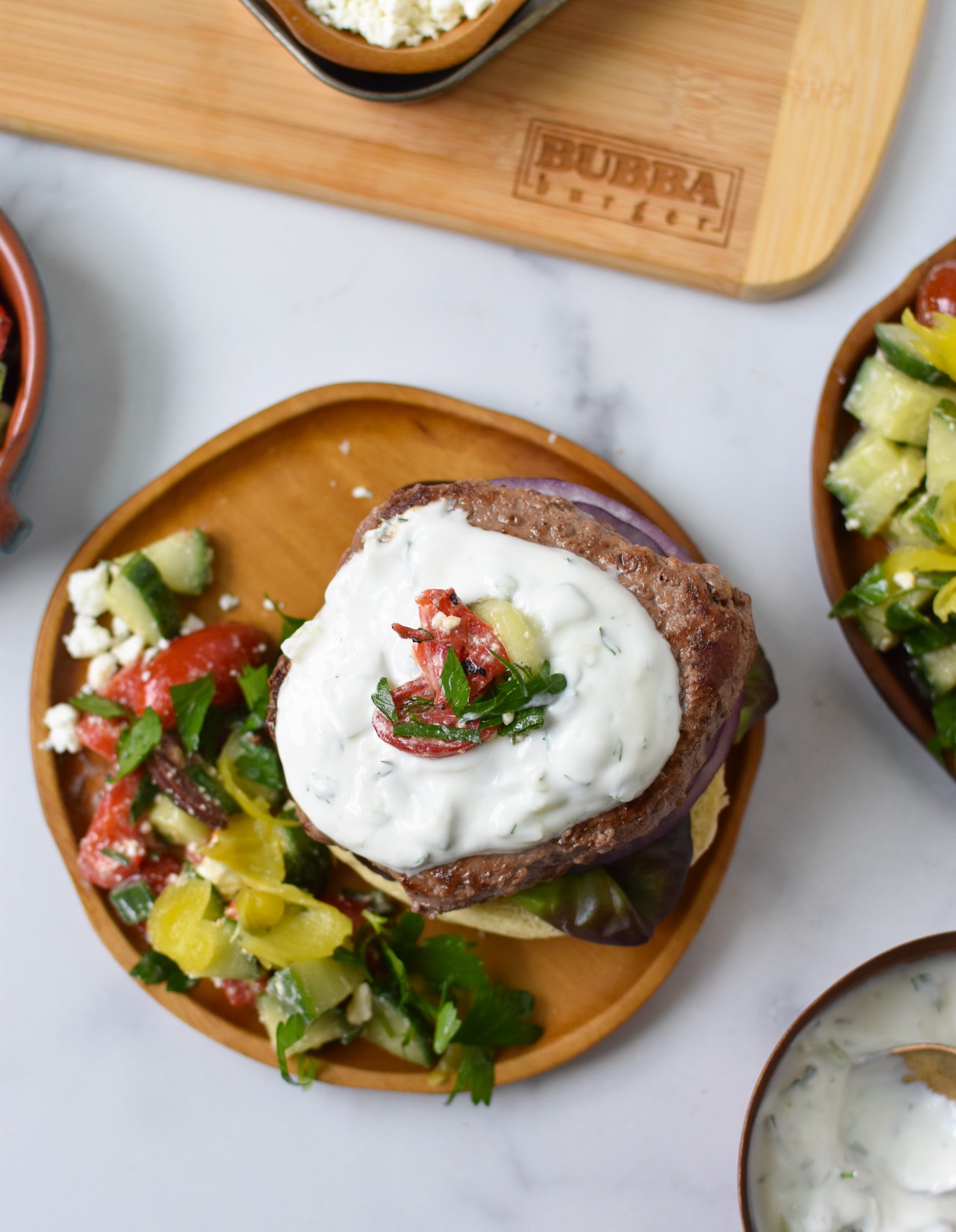Easy Greek Burger Recipe above on wood plate. 