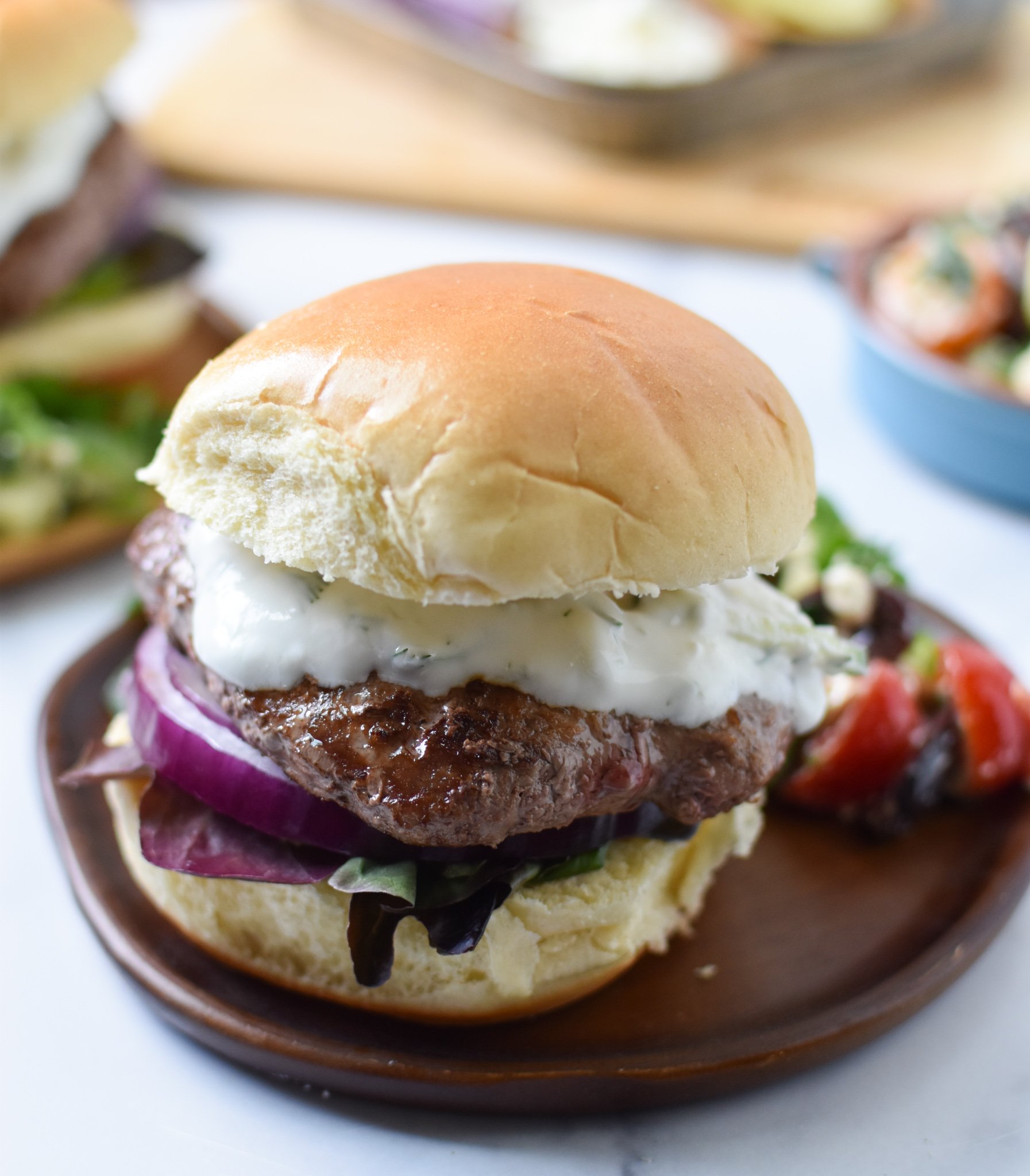 Easy Greek Burger Recipe with bun on plate. 