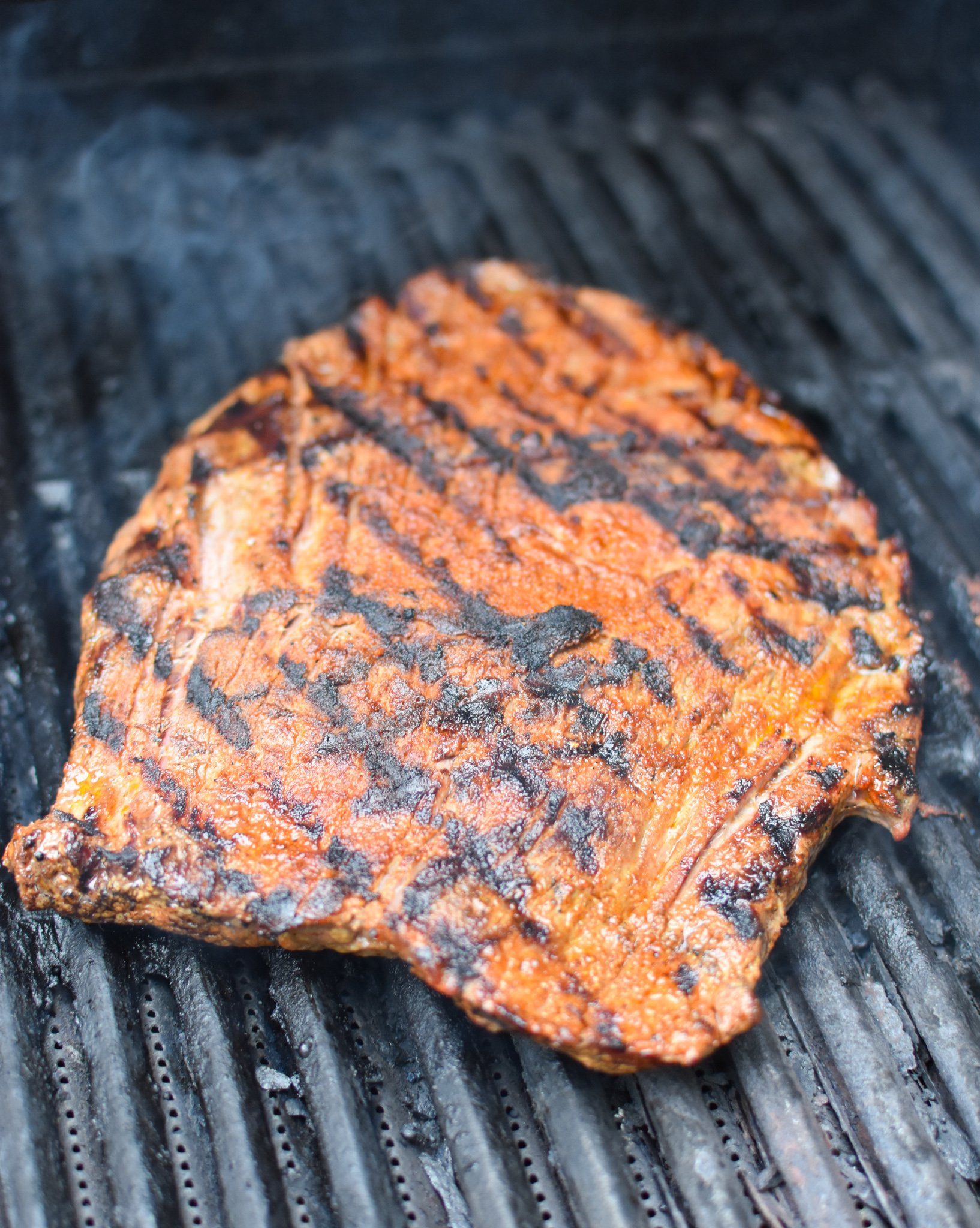 Grilled Flank Steak with Dry Rub on grill. 