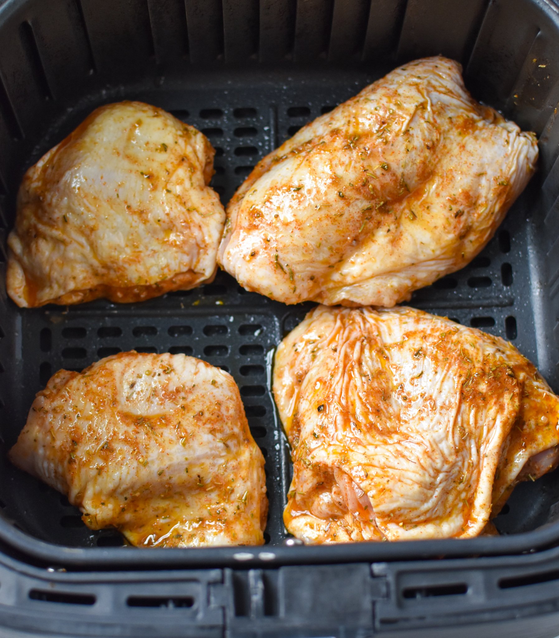 Air Fryer Mediterranean Chicken Thighs in an air fryer.