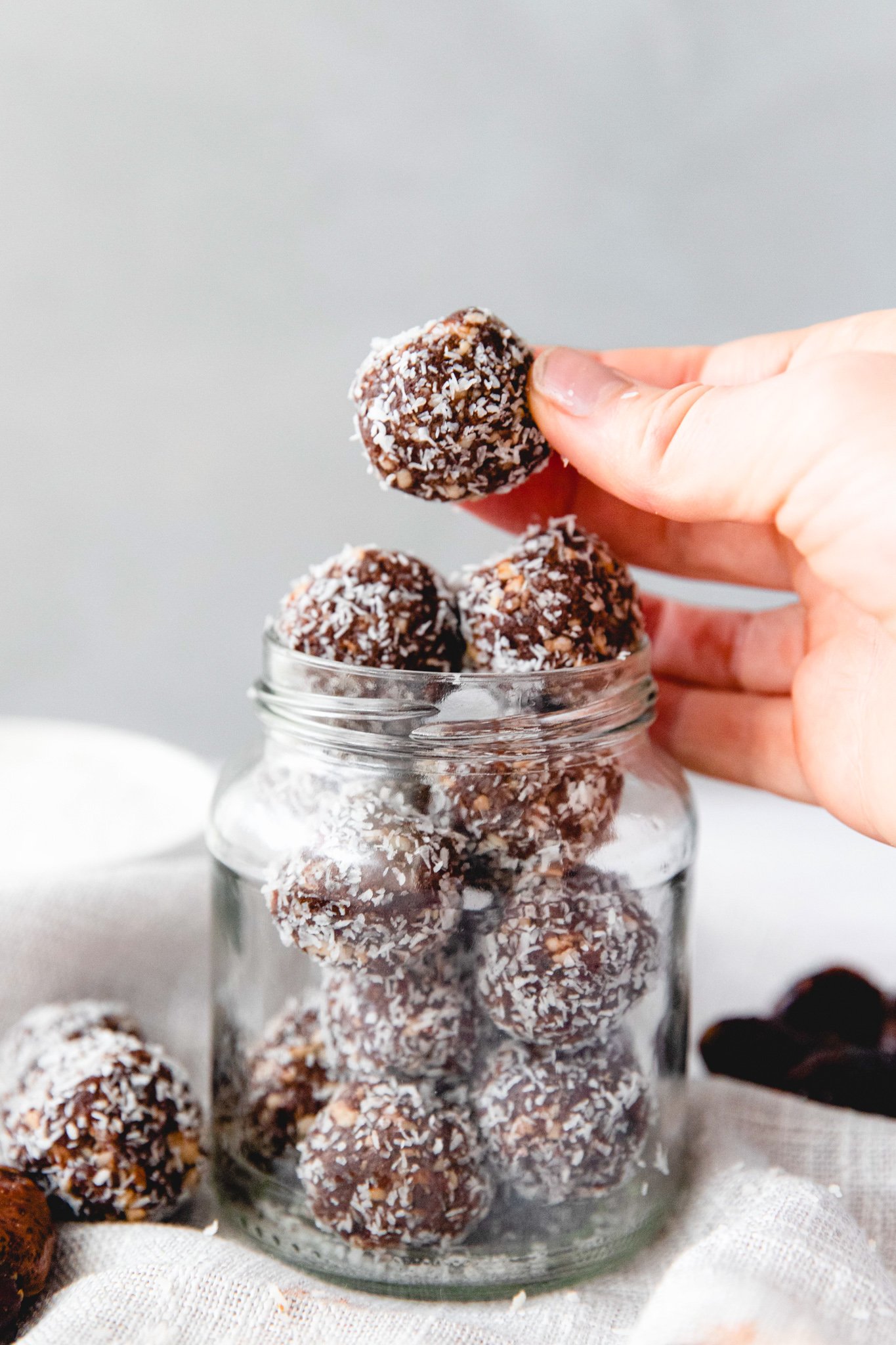 Easy Date Protein Balls in hand above jar.