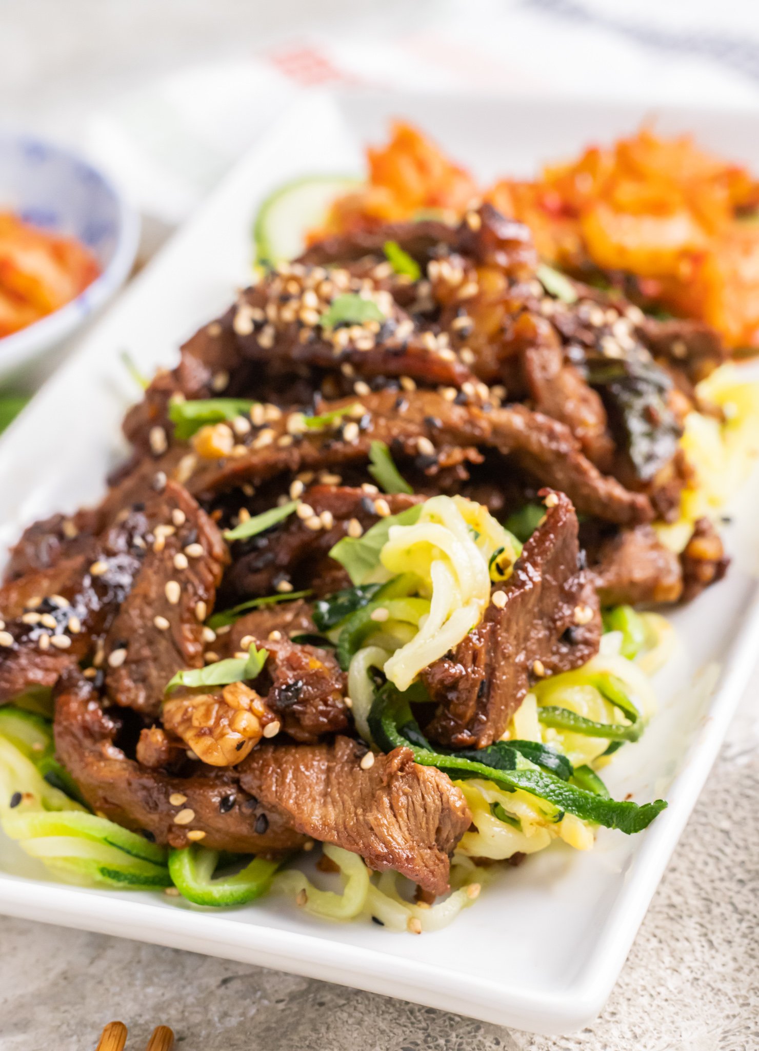 Beef Bulgogi with Zucchini Noodles on a white plate. 
