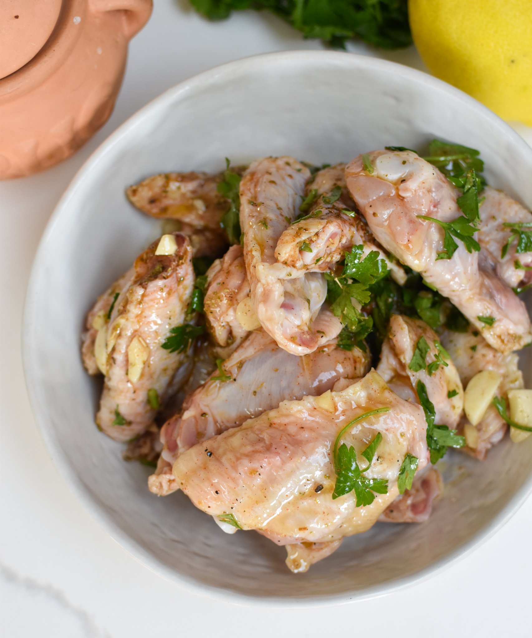 Grilled Mediterranean Chicken Wings marinating in bowl. 