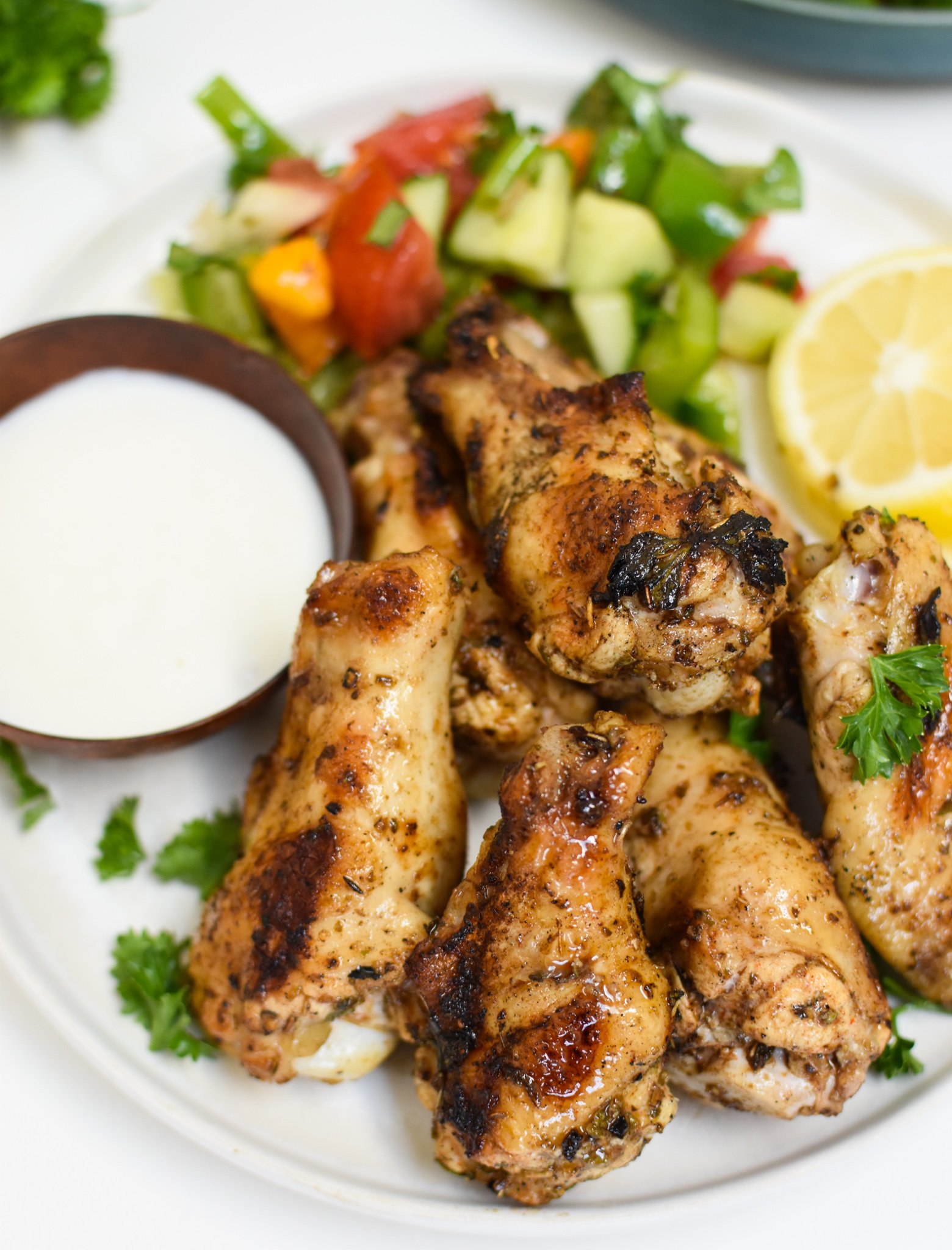 Grilled Mediterranean Chicken Wings on white plate. 