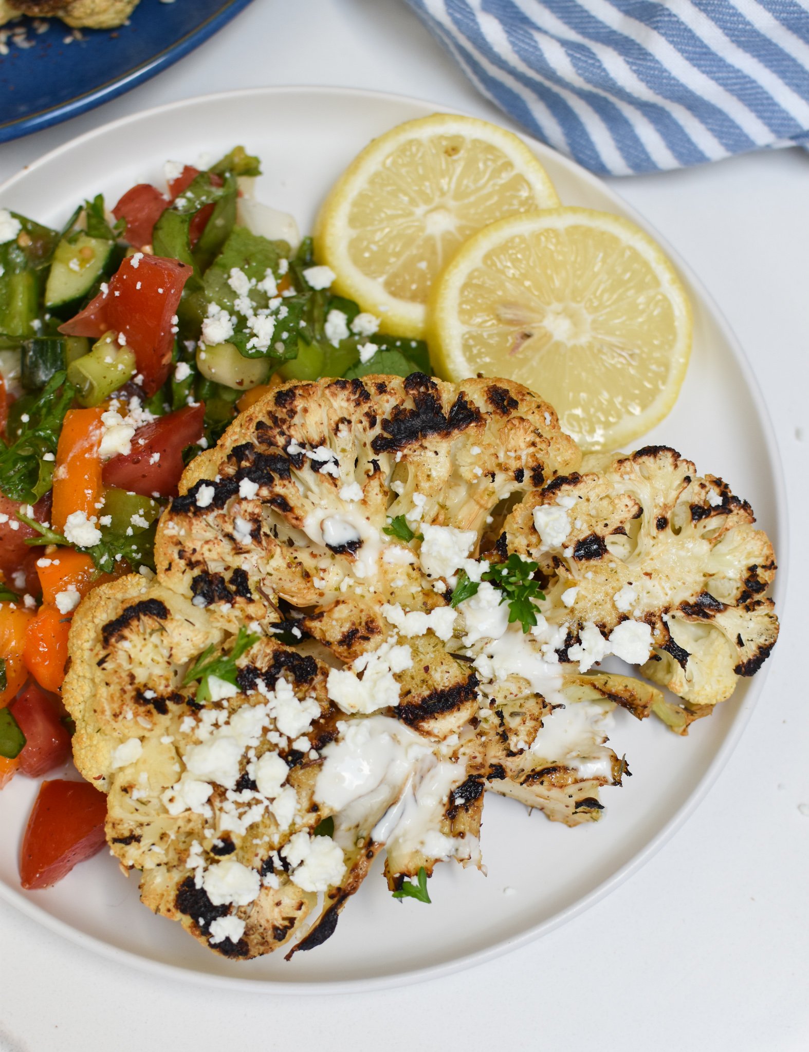 Grilled Cauliflower Steaks with Yogurt Tahini Sauce with salad. 