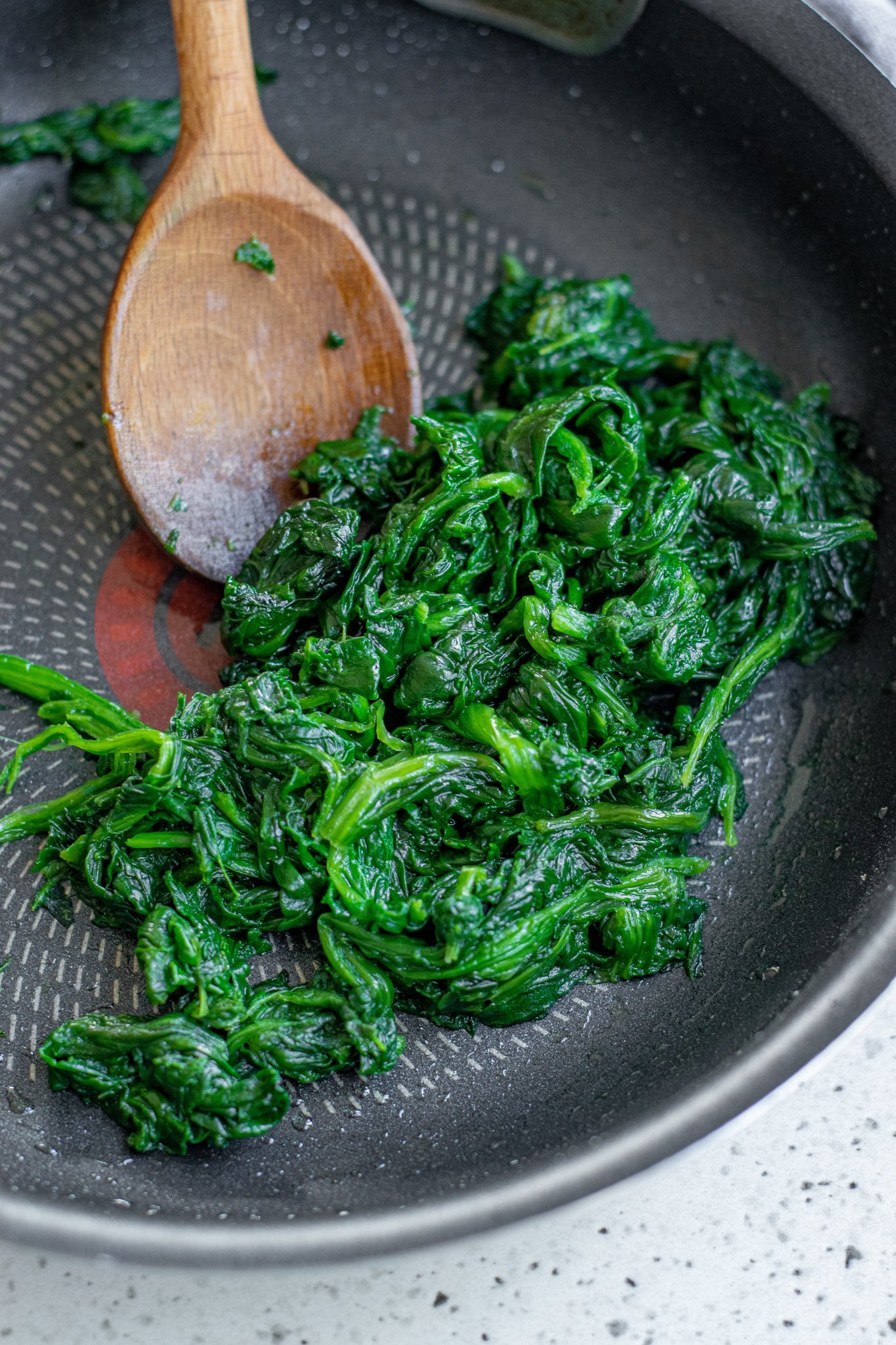 Spanakopita Triangles Recipe spinach in a pan. 