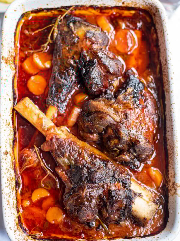 Braised Lamb Shanks Recipe in a white baking dish.