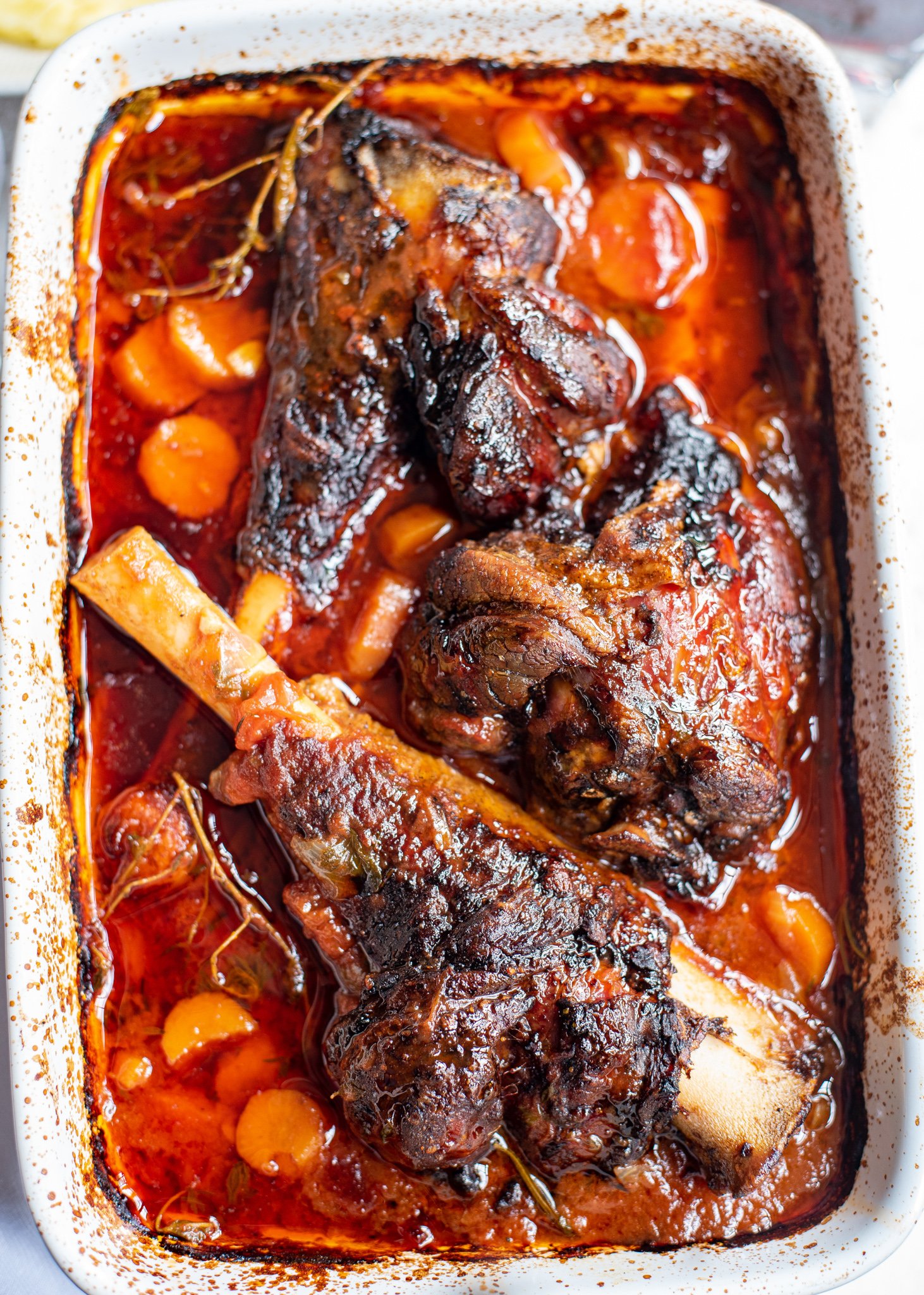 Braised Lamb Shanks Recipe in a white baking dish. 