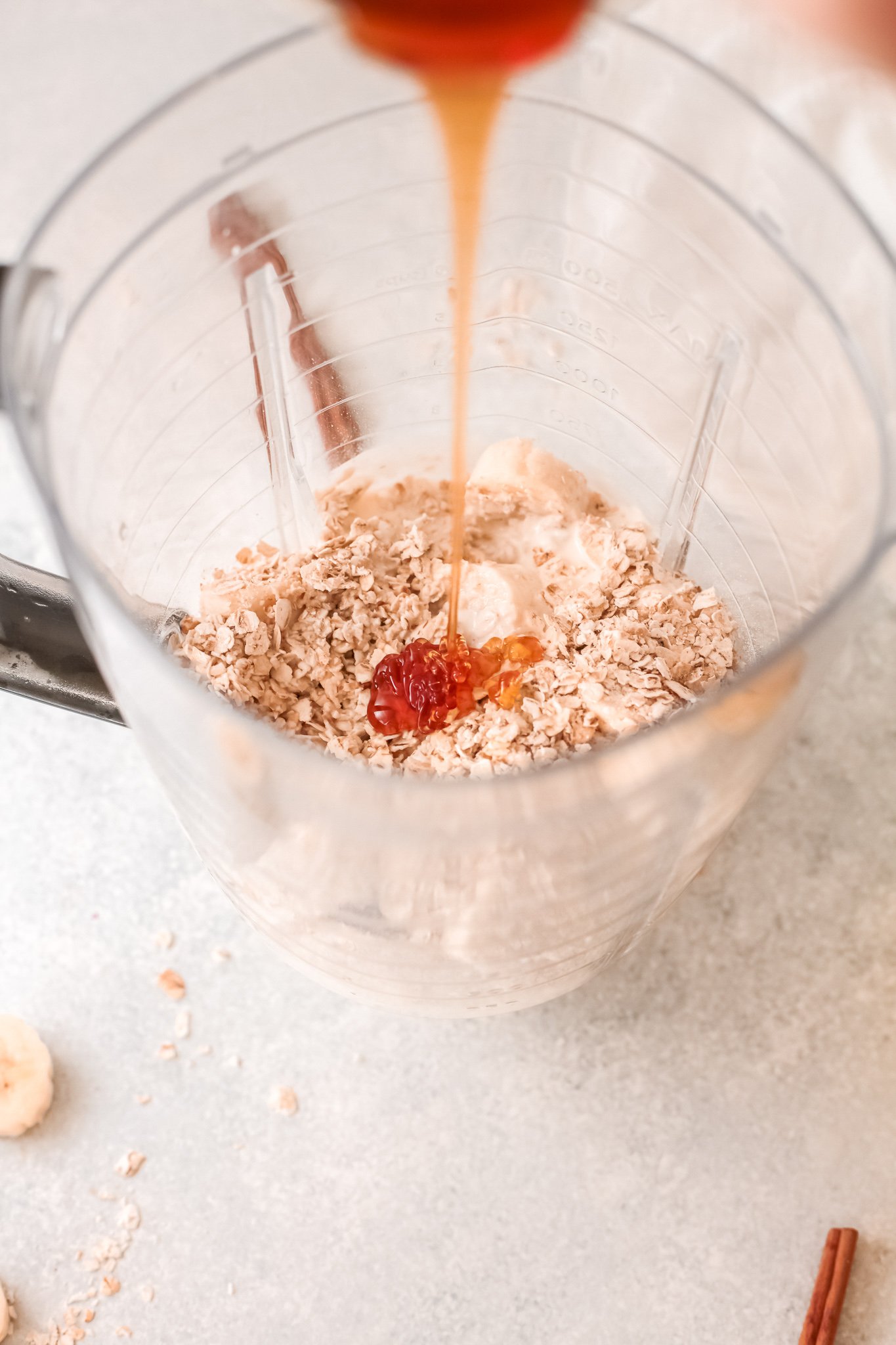 Oat Smoothie Recipe honey bring poured into blender.