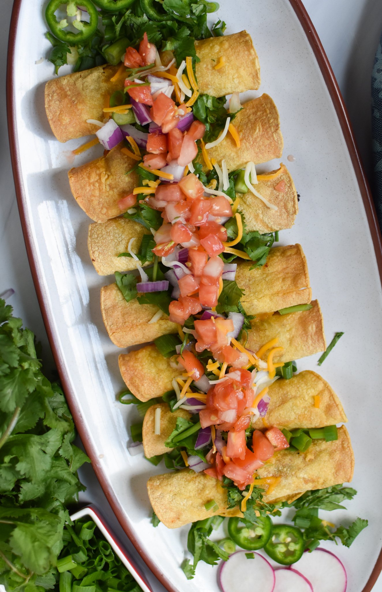 Air Fryer Pork Taquitos on a white platter.