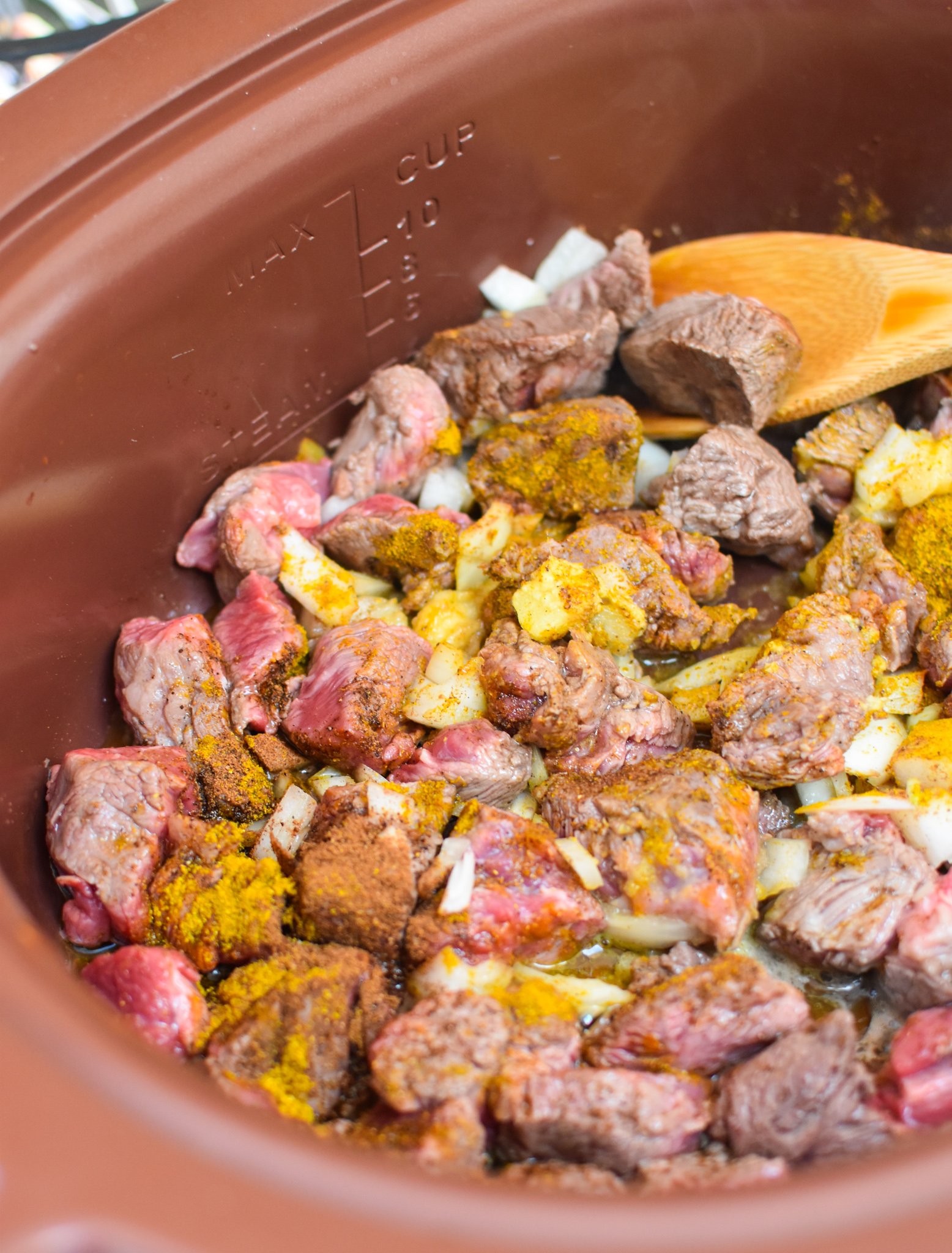 Slow Cooker Beef Curry beef and spices in a crockpot.