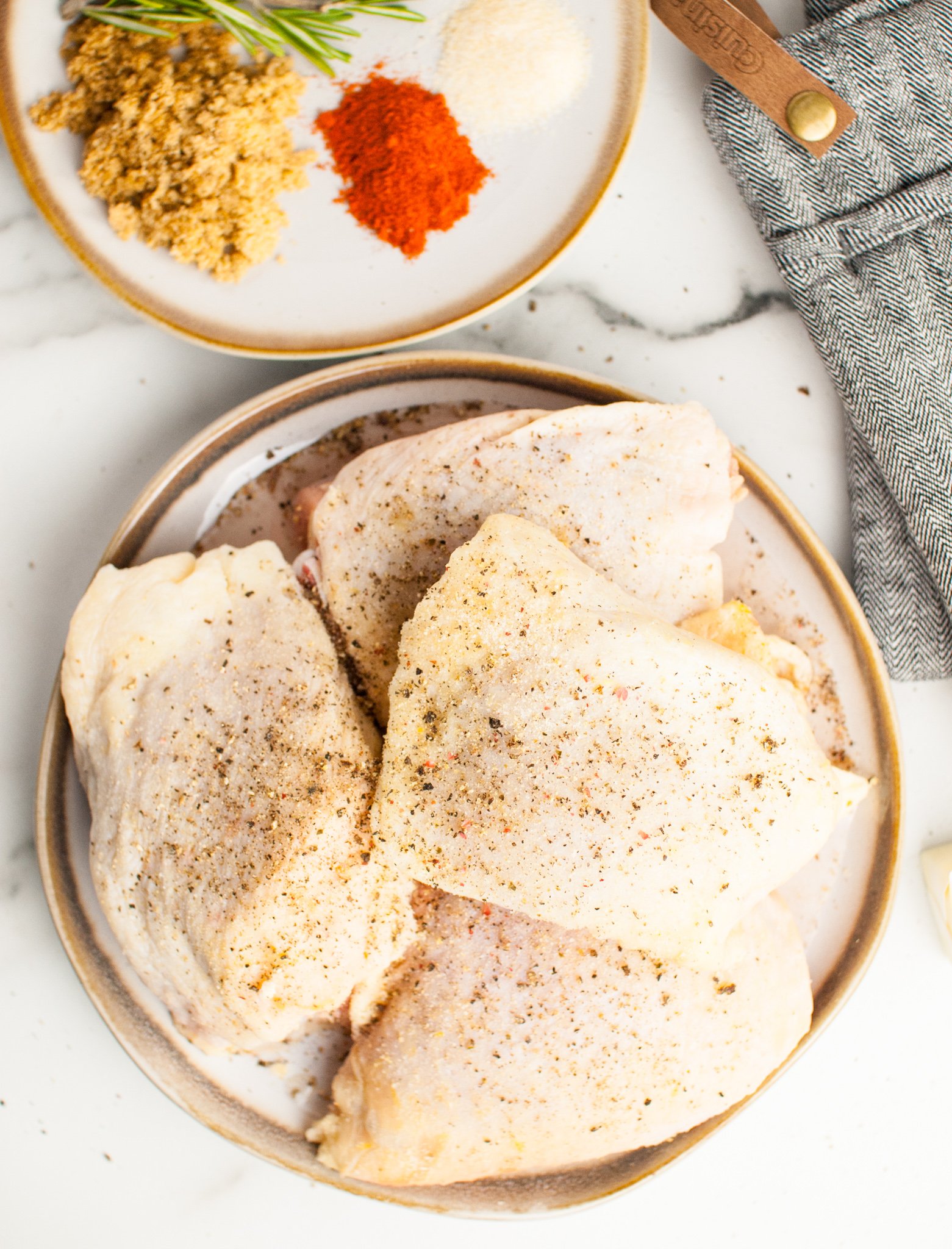 Easy Baked Chicken Thighs chicken seasoned on plate.
