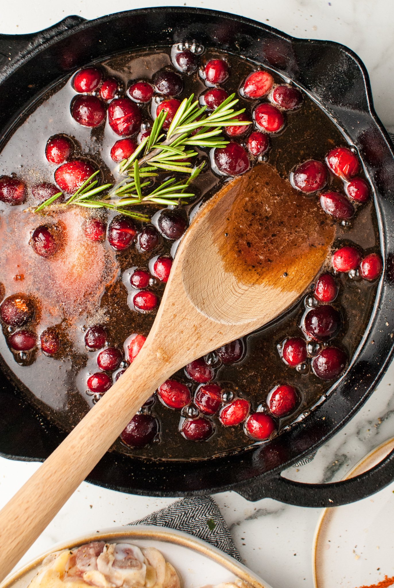Easy Baked Chicken Thighs cranberry sauce in skillet.
