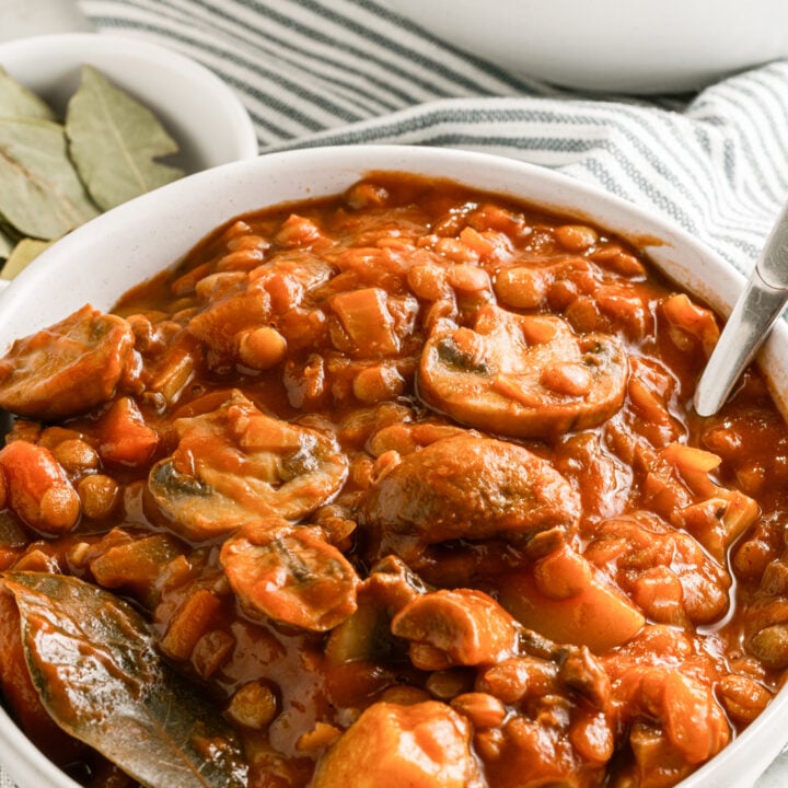 Lentil Mushroom Stew in white bowl with spoon.