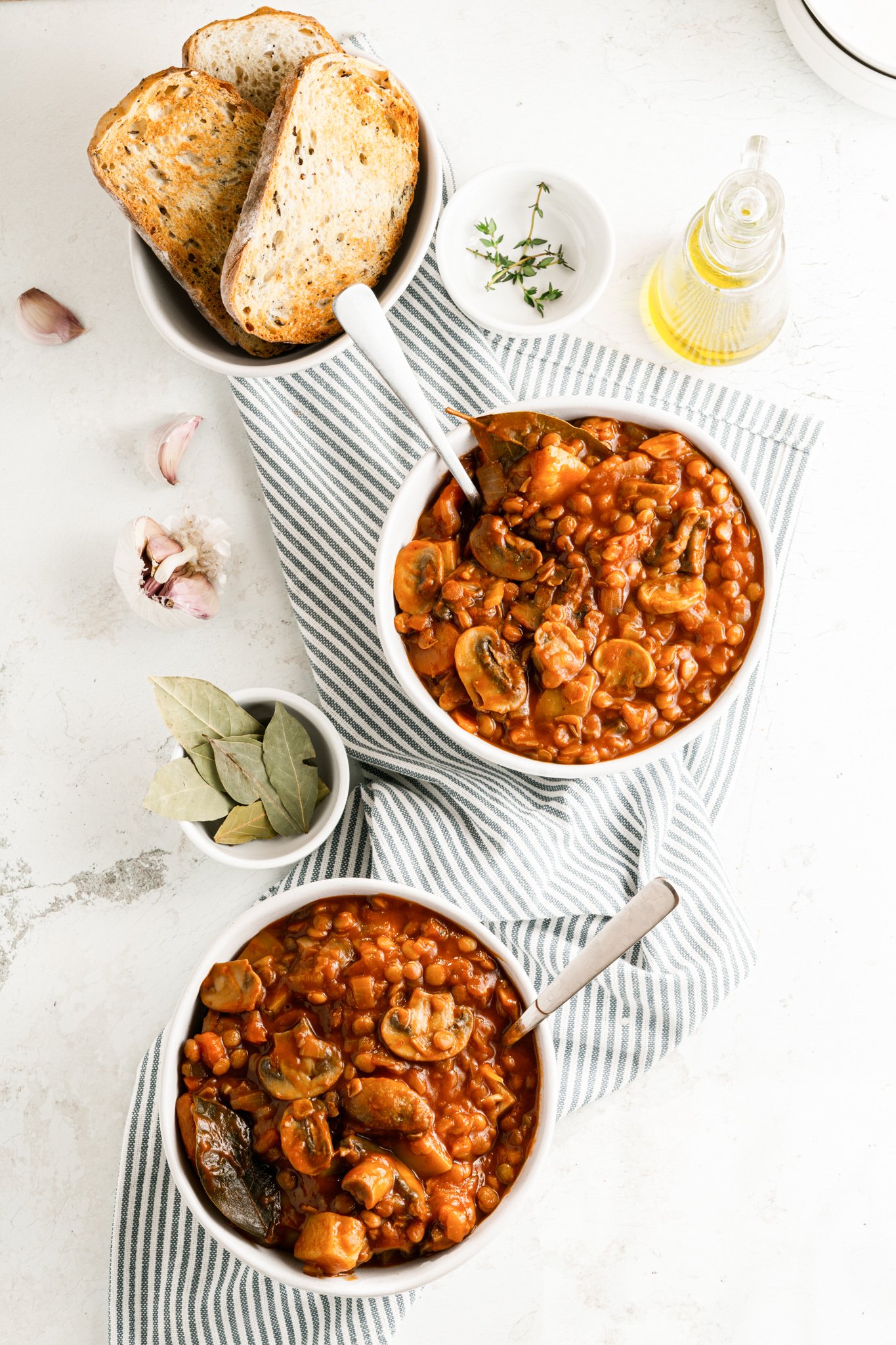 Lentil Mushroom Stew in white bowls with spoons. 
