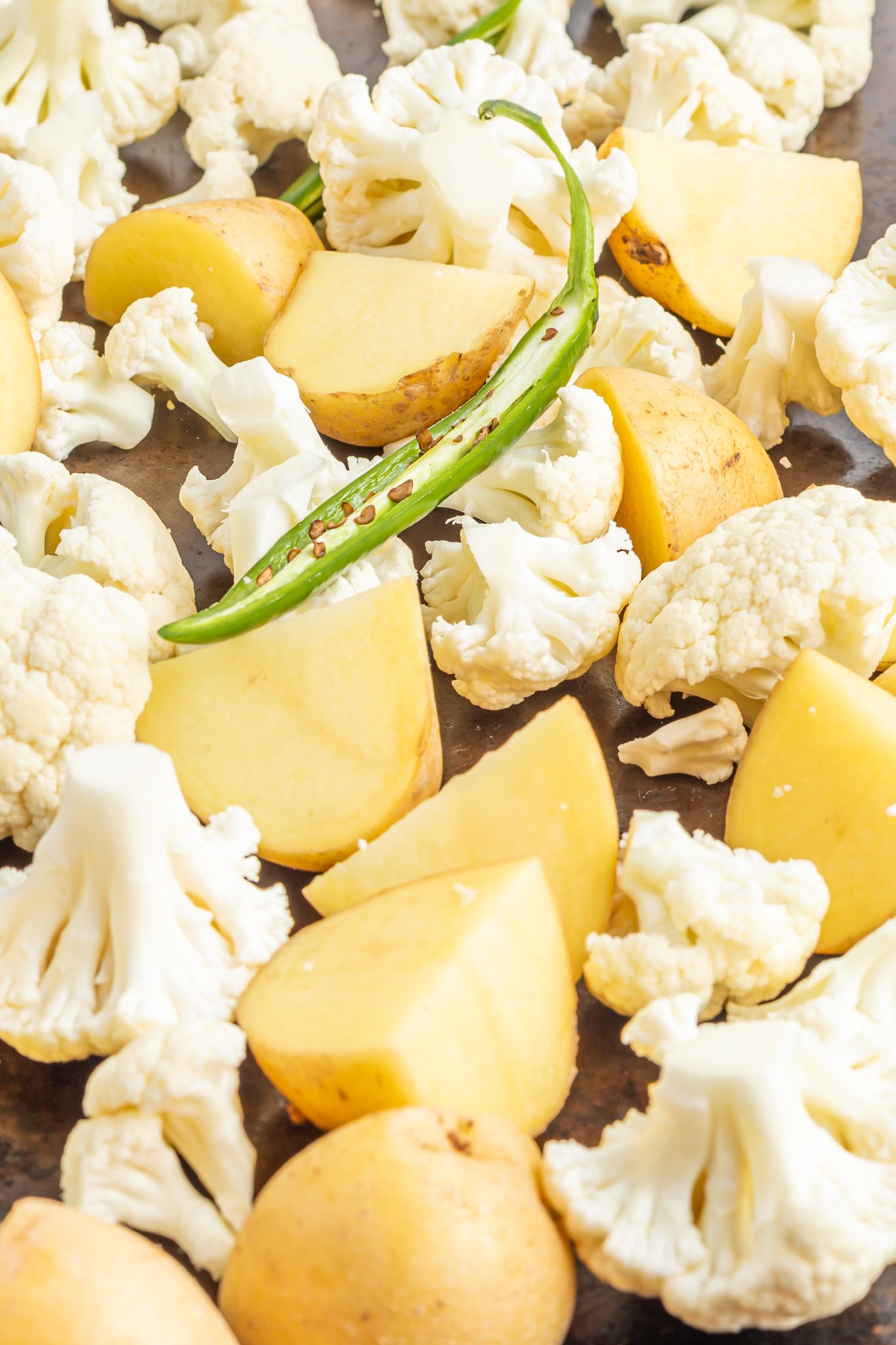 Cauliflower Curry Recipe roasting potatoes on a pan.