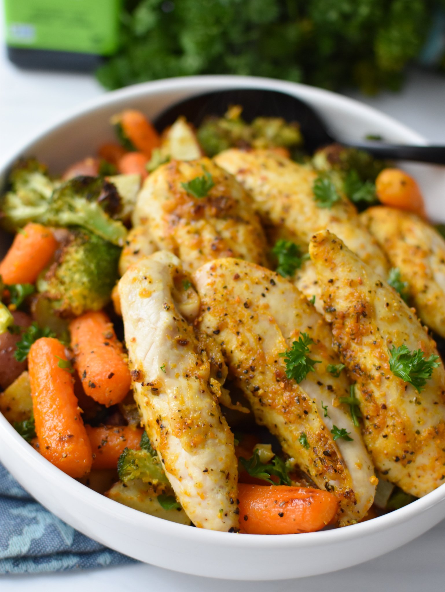 Sheet Pan Lemon Parmesan Chicken Tenders chicken and vegetables in a bowl. 