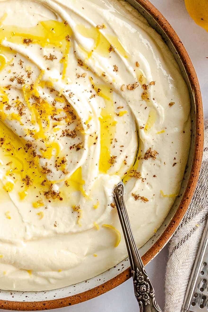 Close up of whipped feta dip with za'atar and olive oil drizzle ready to serve