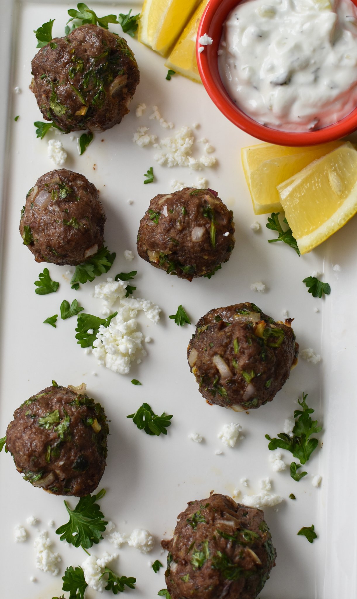 Mediterranean Baked Beef Meatballs on a white platter.