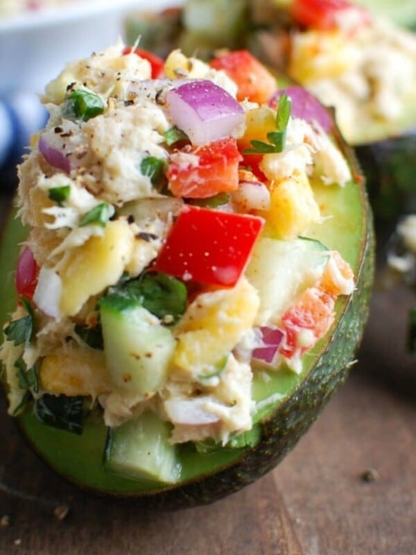 Tropical Tuna Stuffed Avocado on a cutting board with a napkin in the background