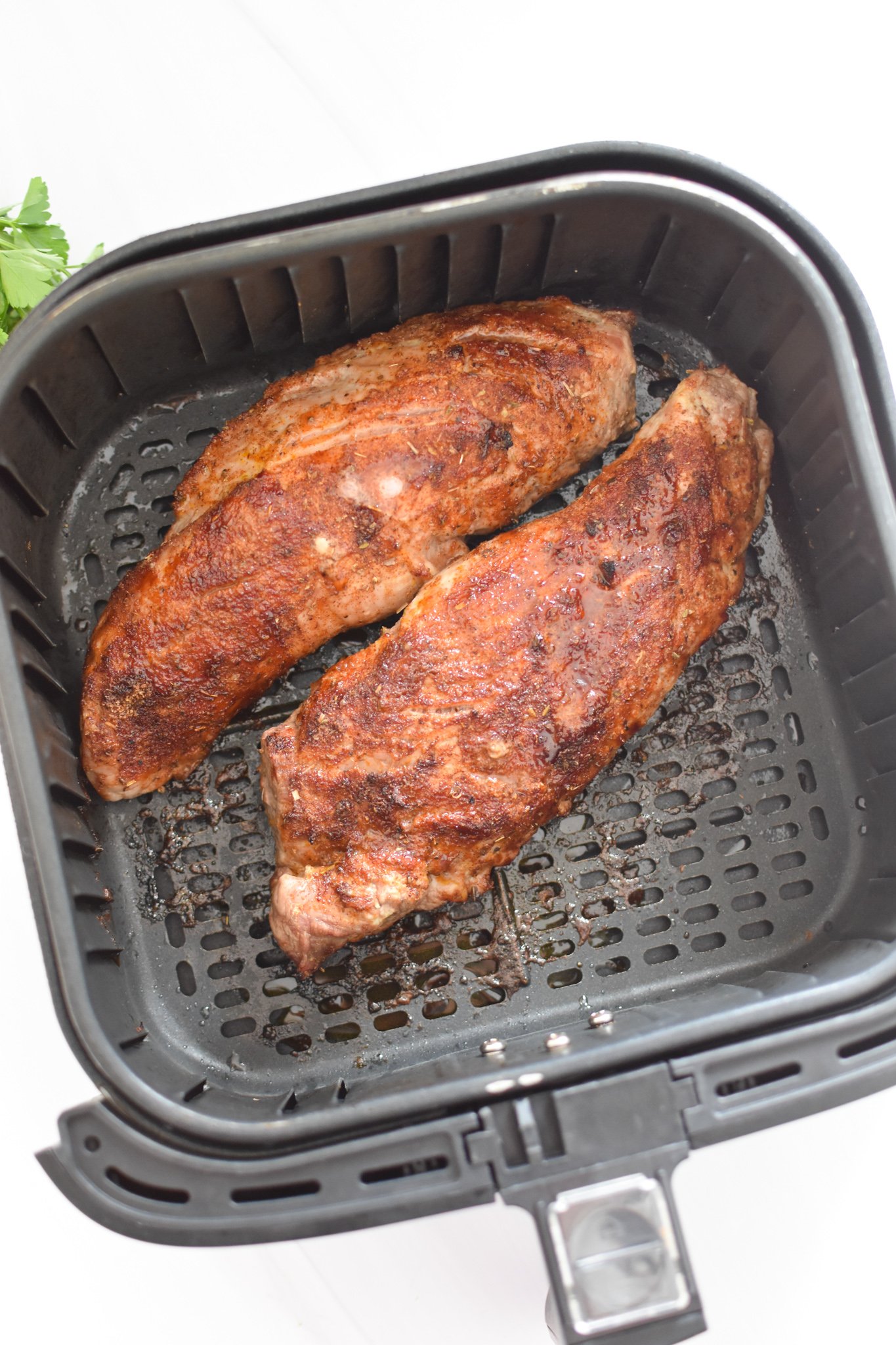 Air Fryer Pork Tenderloin pork in the air fryer basket. 