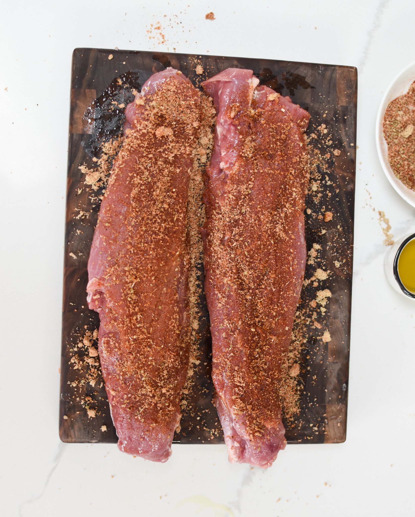 Air Fryer Pork Tenderloin with rub on a cutting board. 